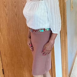 Pink skirt with a white top and pink flats.